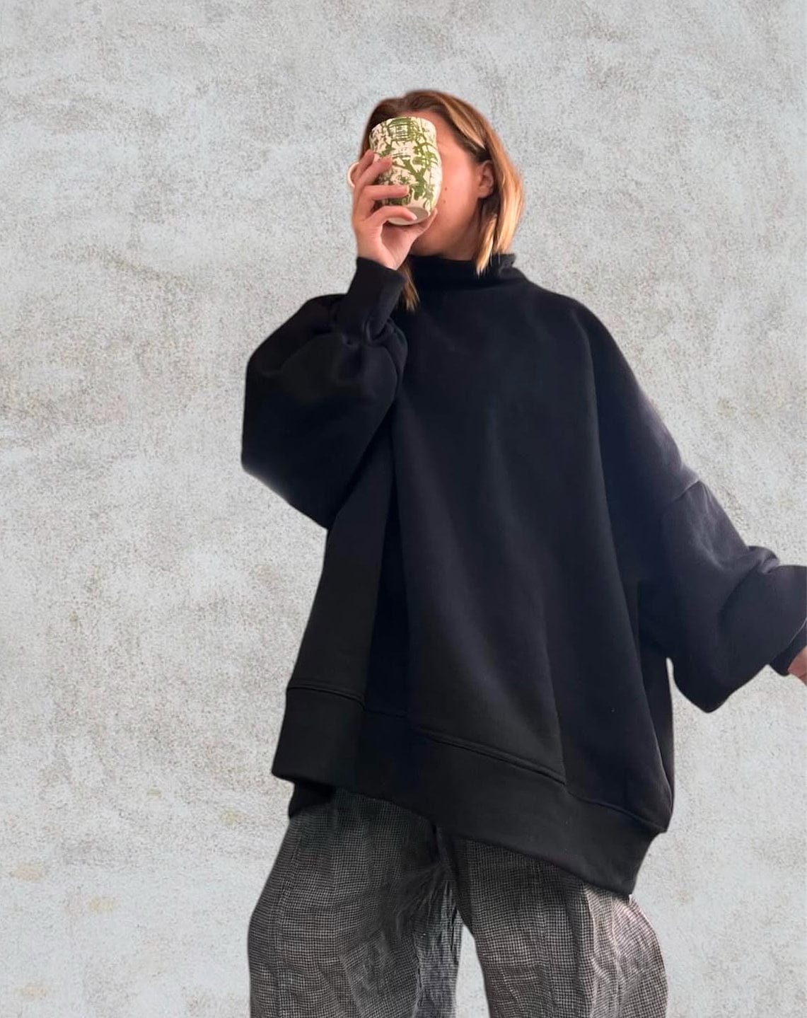 Woman in black turtleneck sweater holding a mug, FullSizeRender