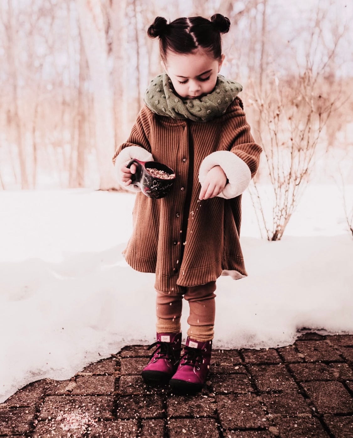 Girl in winter coat playing with snow