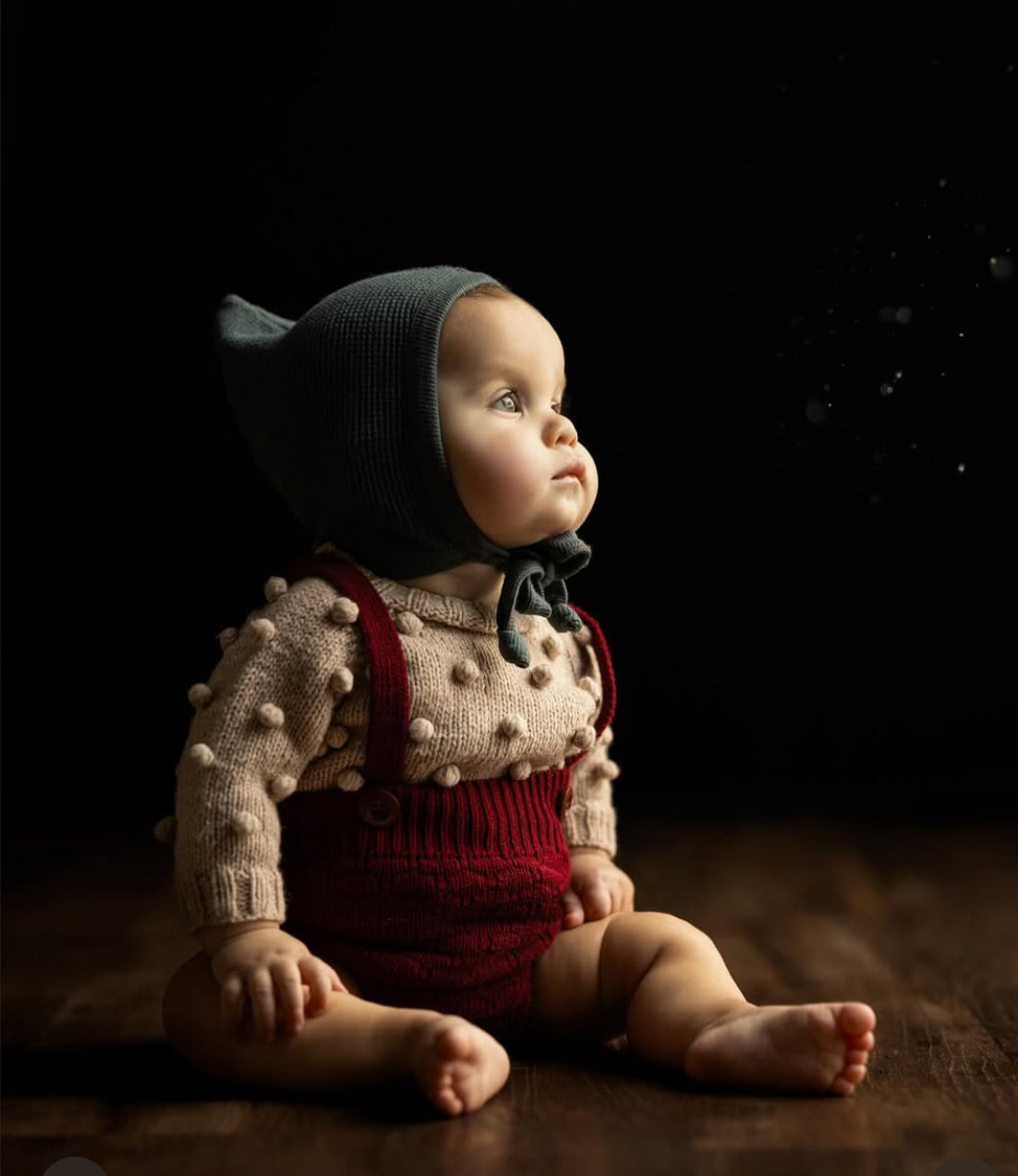Baby in bonnet looking up