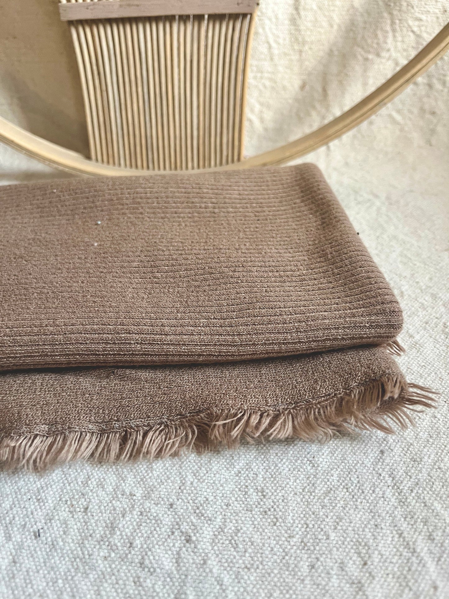 Tan woven fabric with fringe and weaving loom