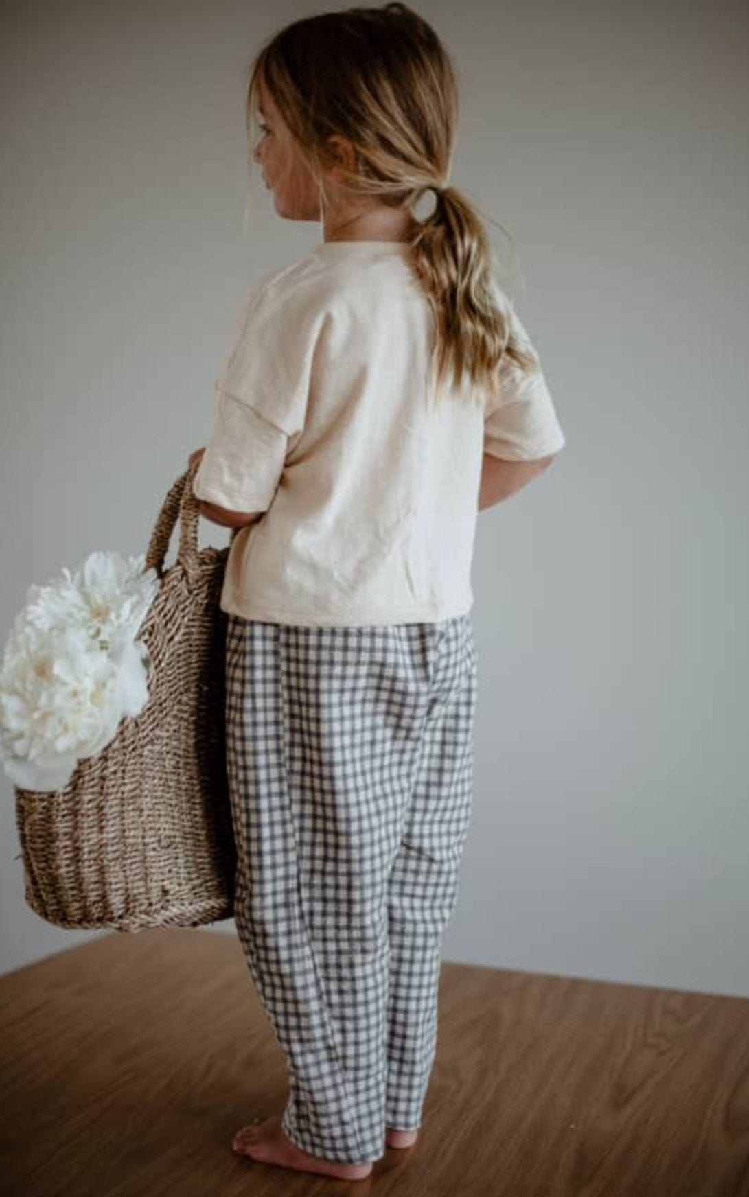 Girl holding basket, wearing gingham pants - FullSizeRender