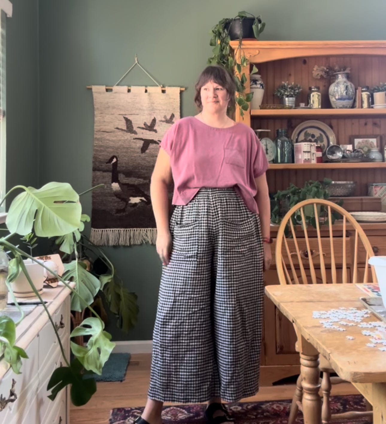 Woman in pink top and checkered pants.