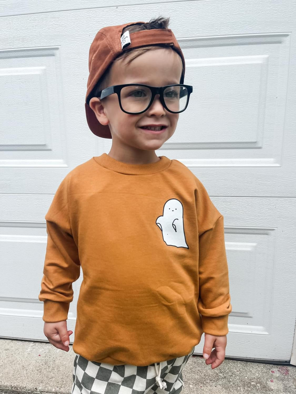 Toddler wearing glasses and a ghost sweatshirt (IMG-2255)