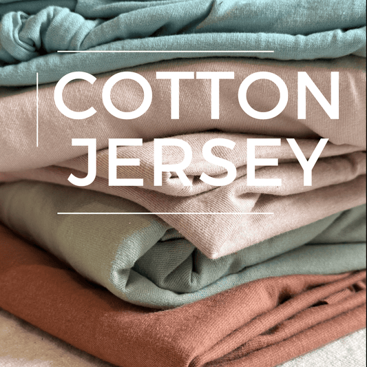 Stack of folded pastel-colored cotton jersey fabric.