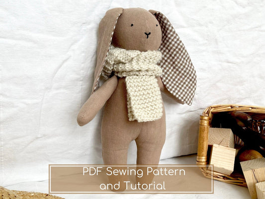 Stuffed brown bunny wearing a scarf, with basket and blocks.