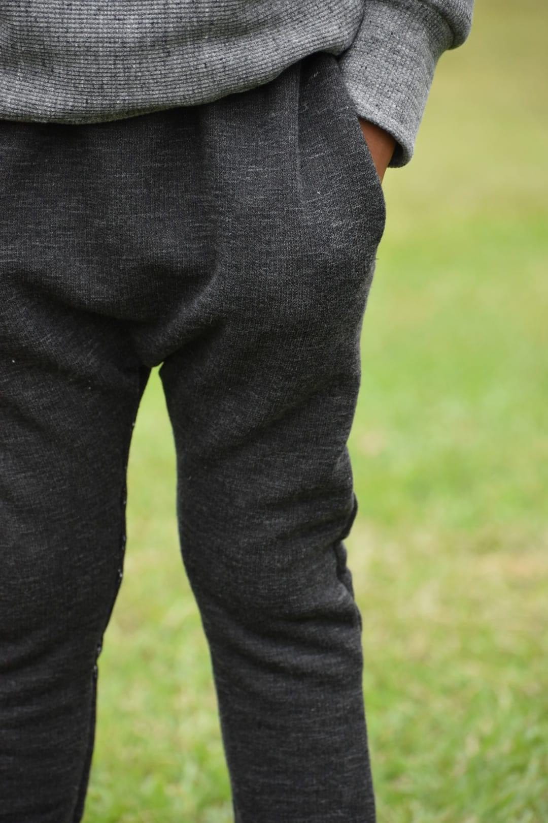 Person wearing gray sweater and dark gray sweatpants.