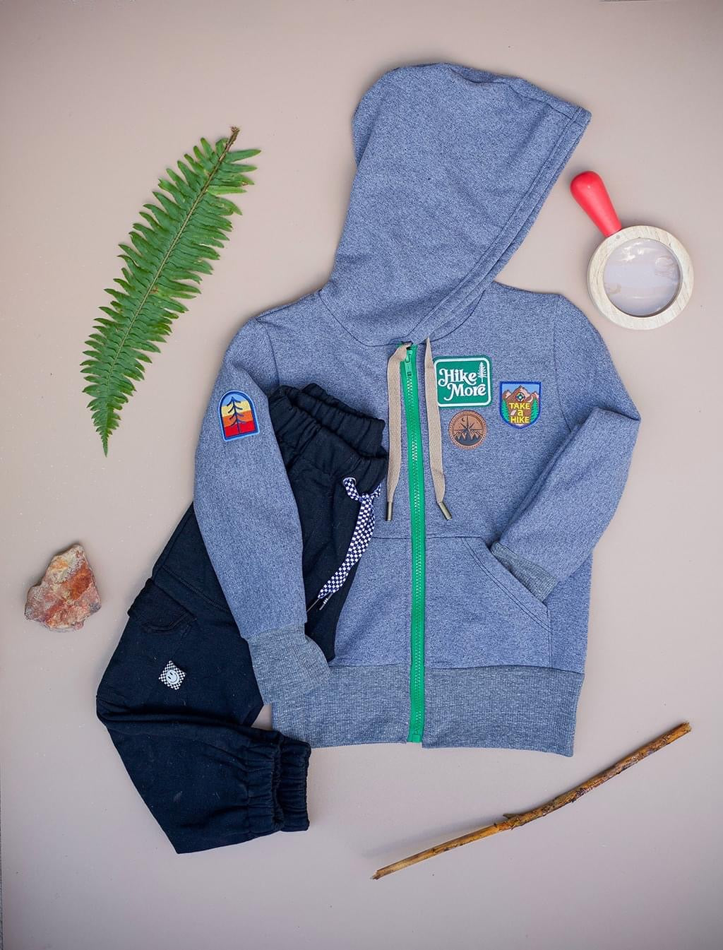 Blue hoodie and black pants with nature-themed accessories.