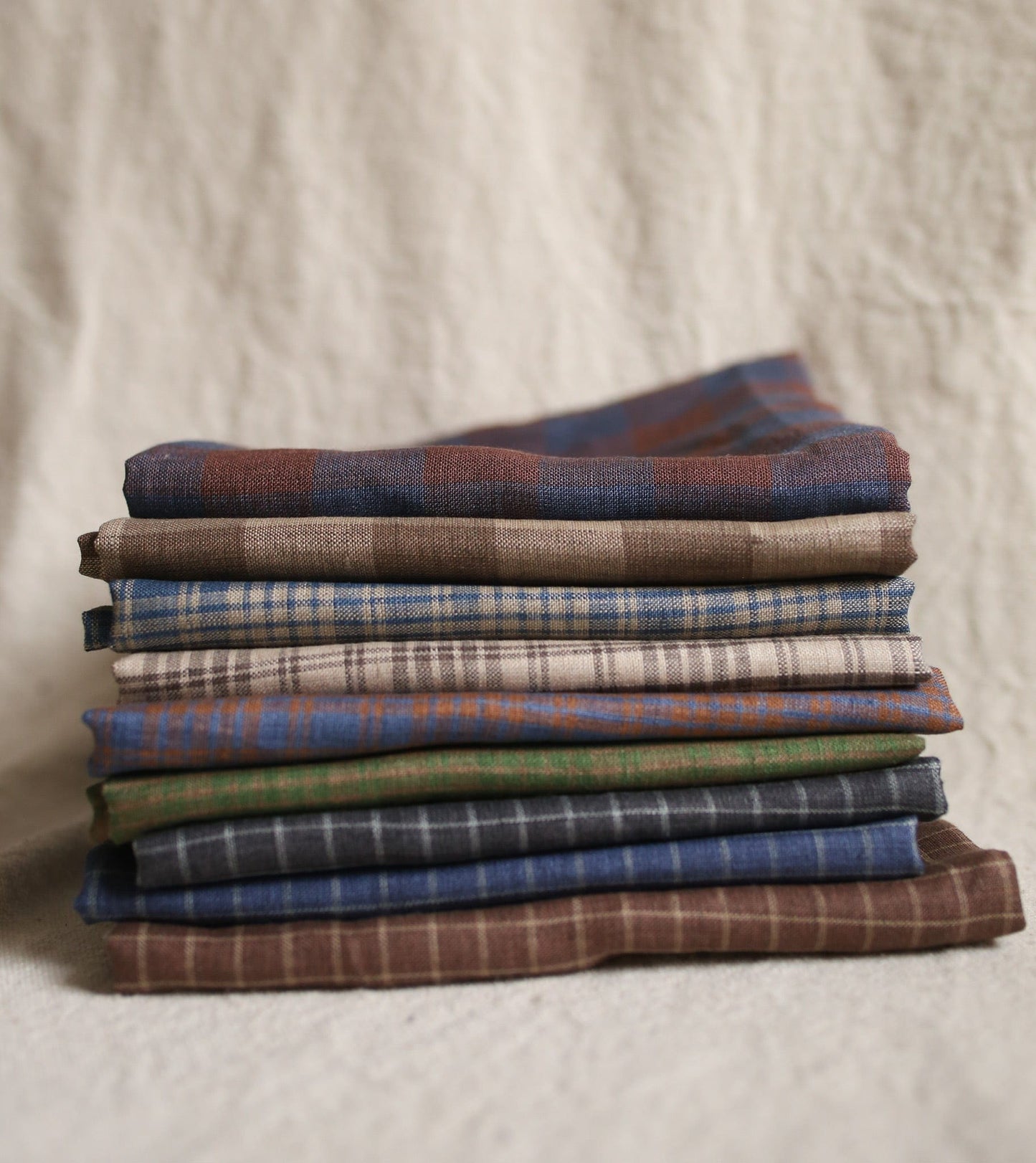 Pile of folded plaid fabric.