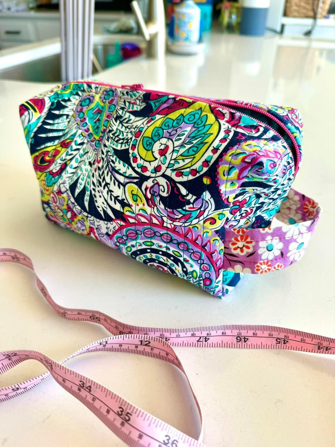 Colorful paisley patterned pouch and measuring tape.