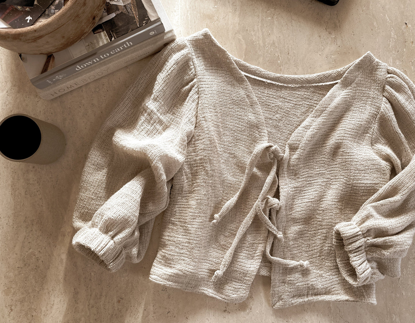 Beige tie-front blouse with puffy sleeves.