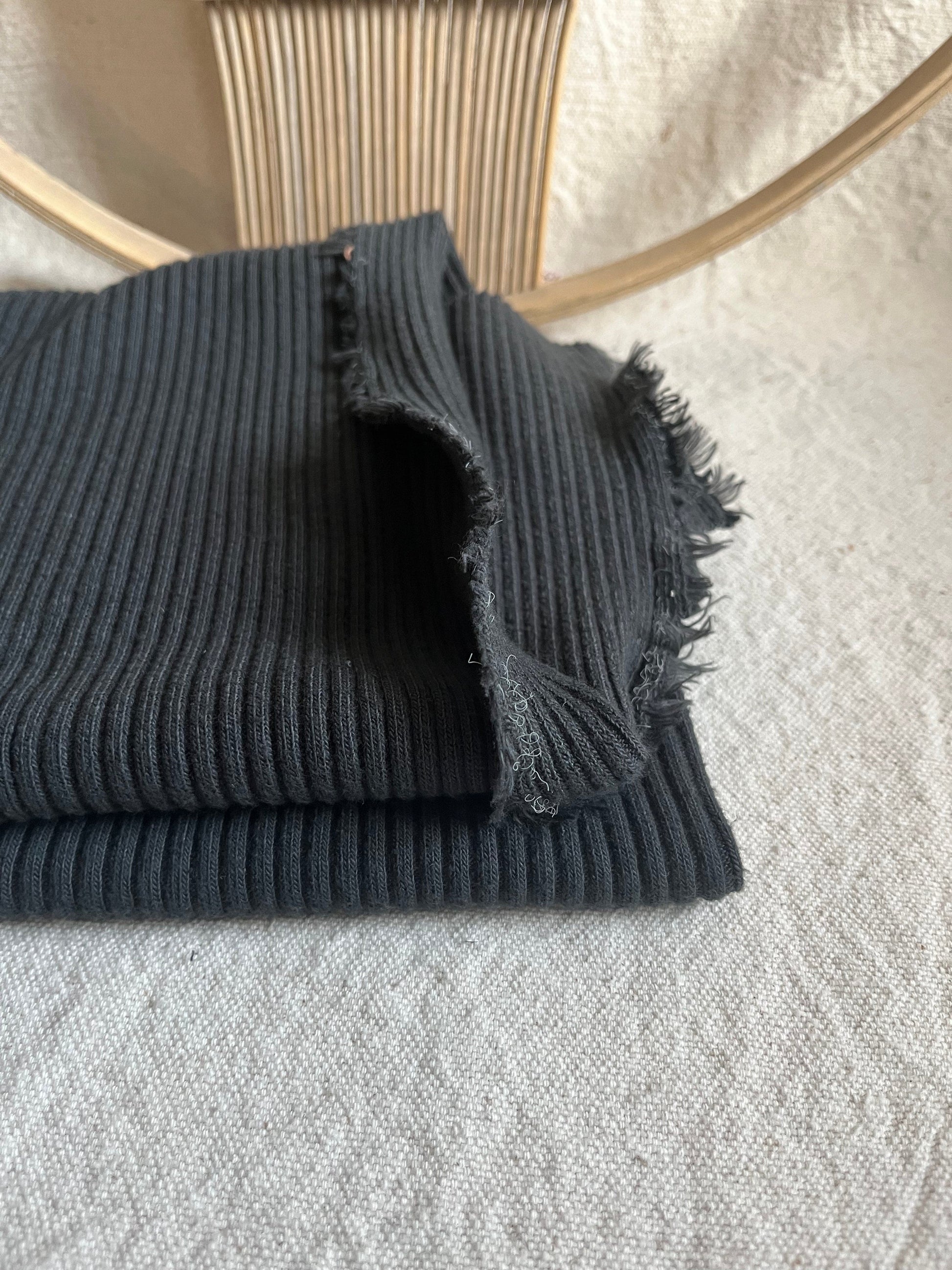 Folded dark gray ribbed fabric.
