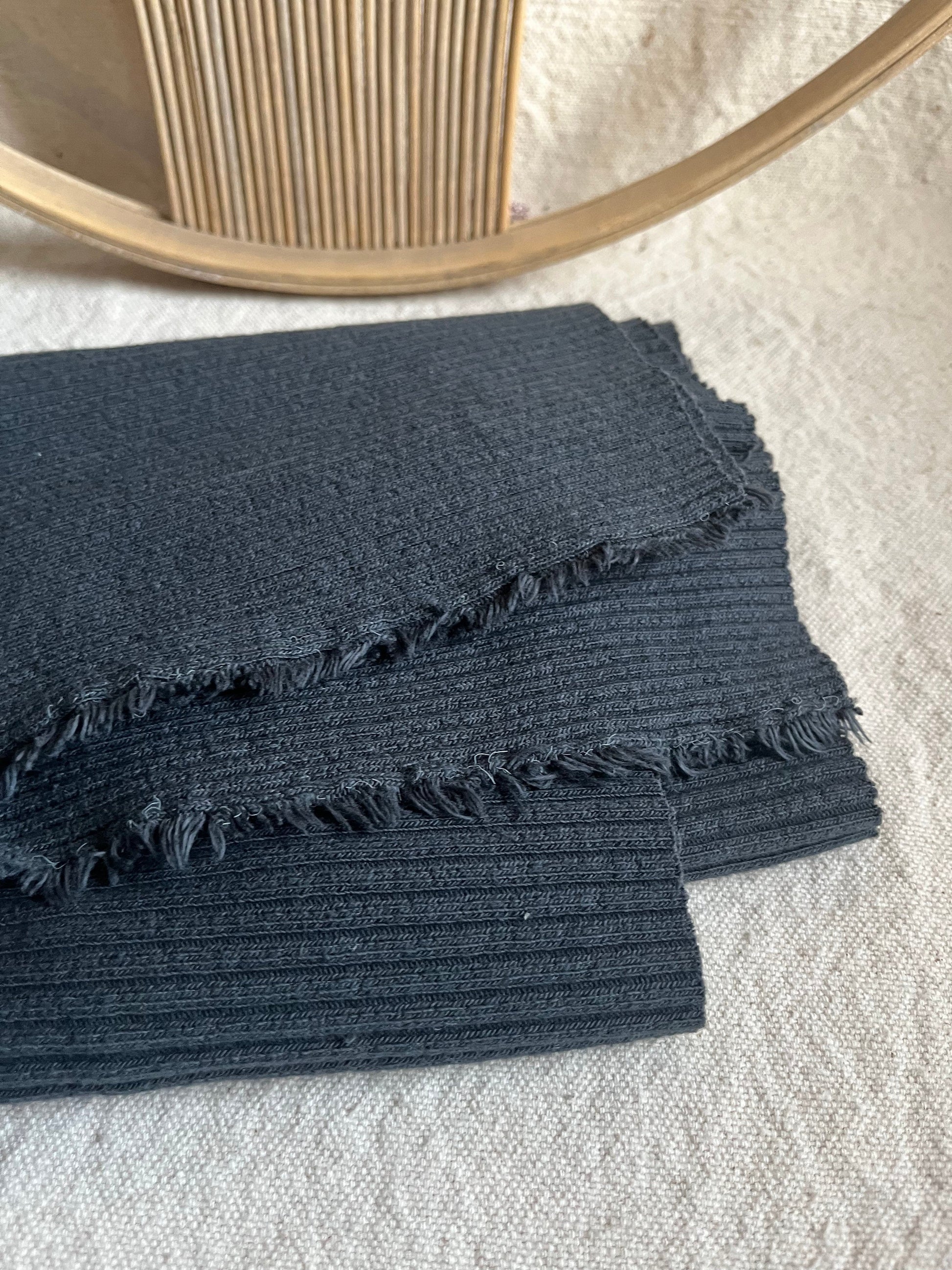 Folded dark blue fabric with fringe.