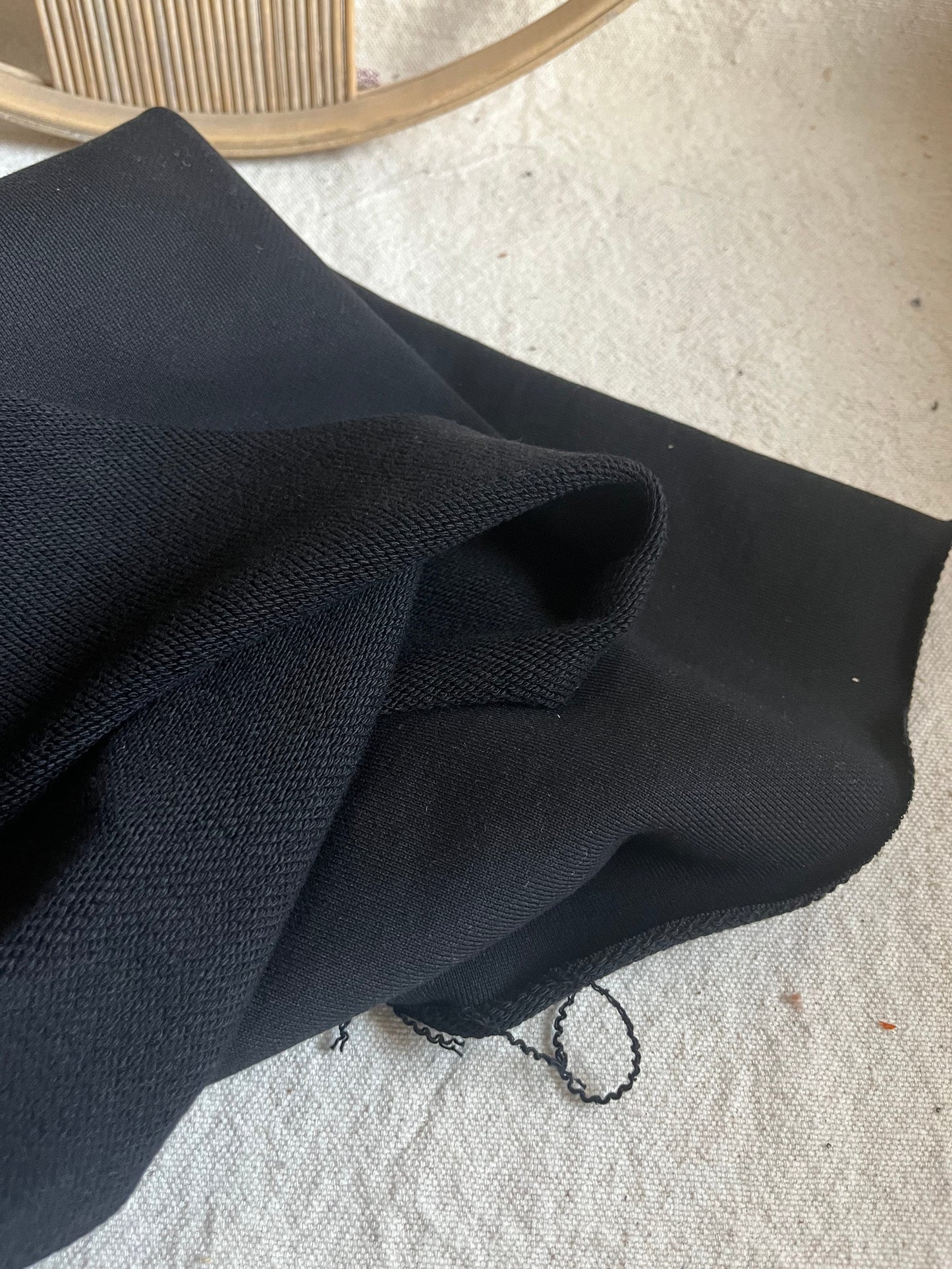 Black fabric folded on a light surface.