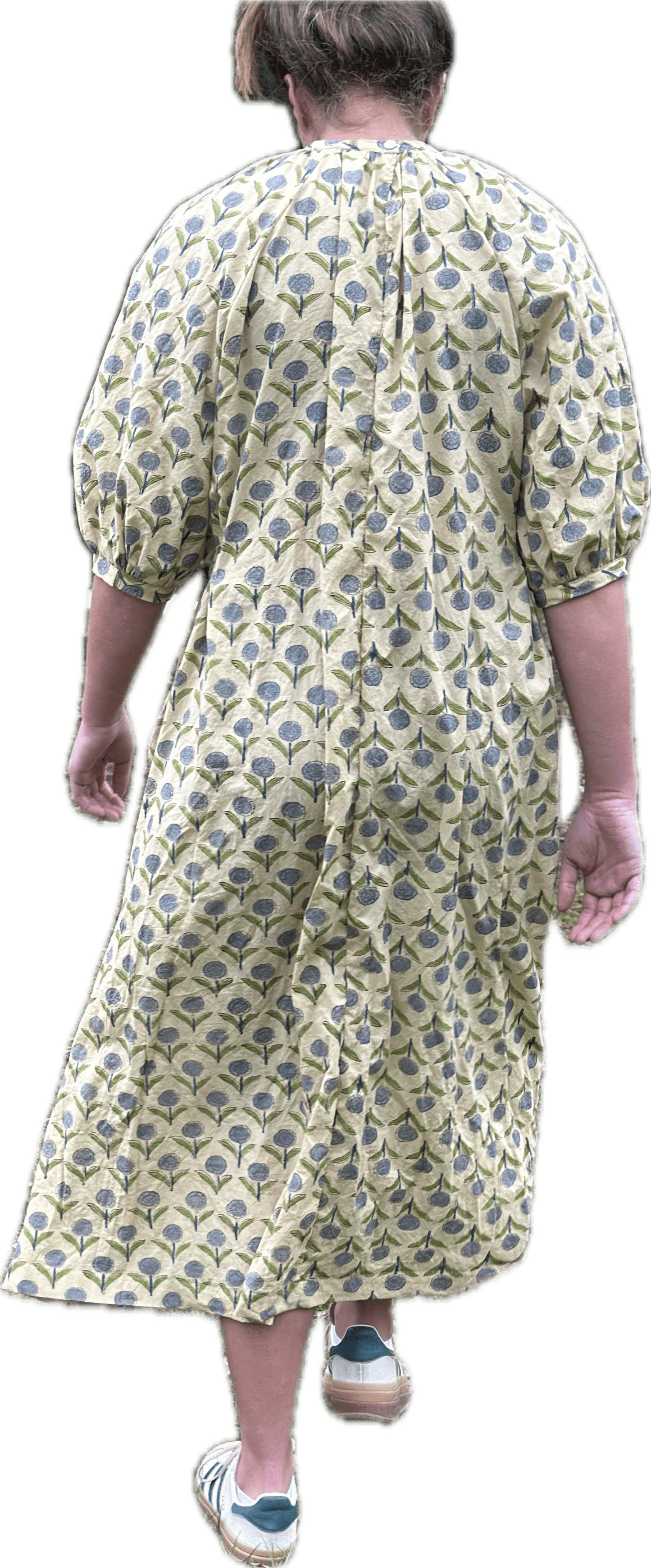 Woman in floral dress walking away.