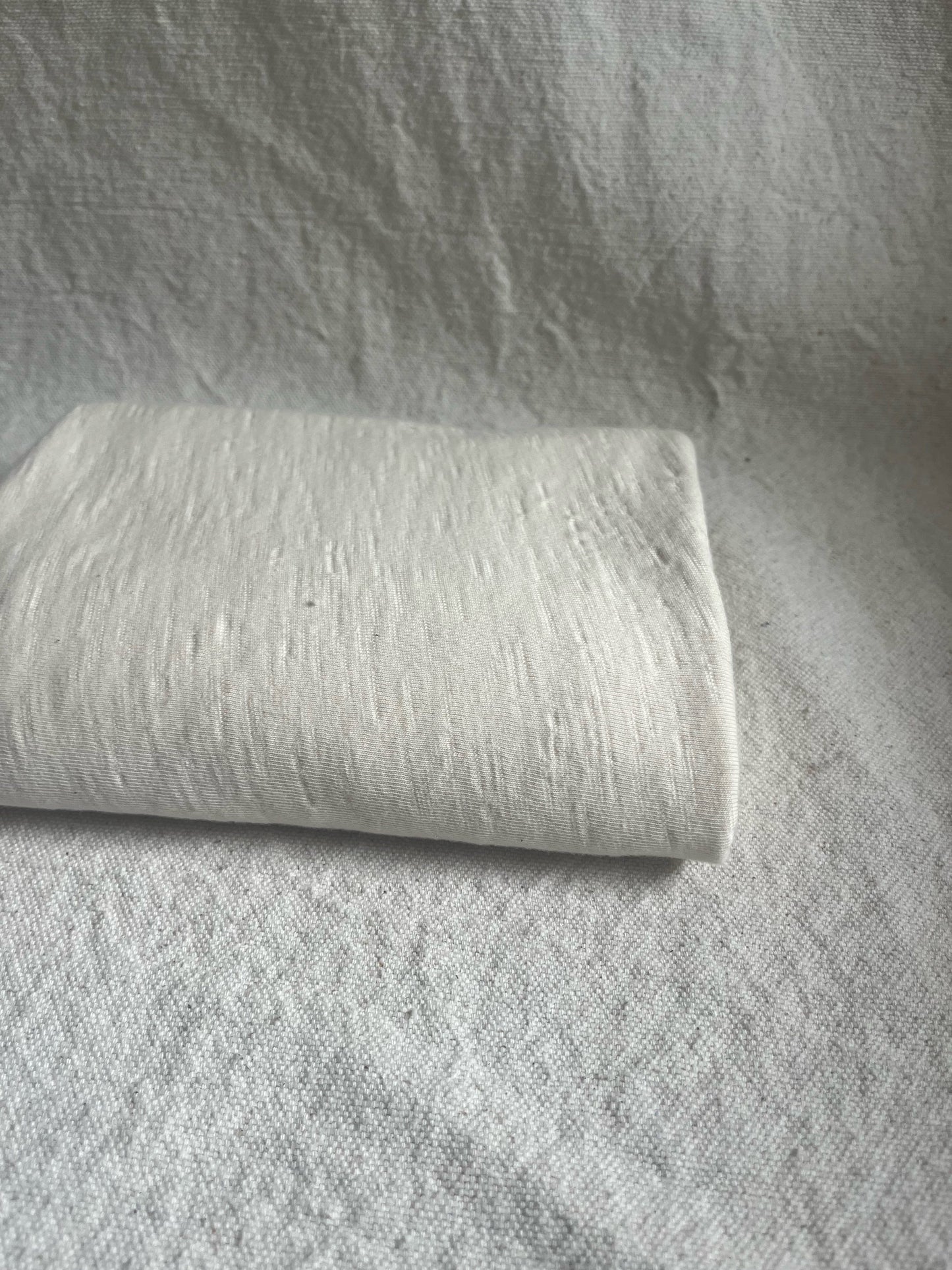 White rectangular cloth on a textured surface.