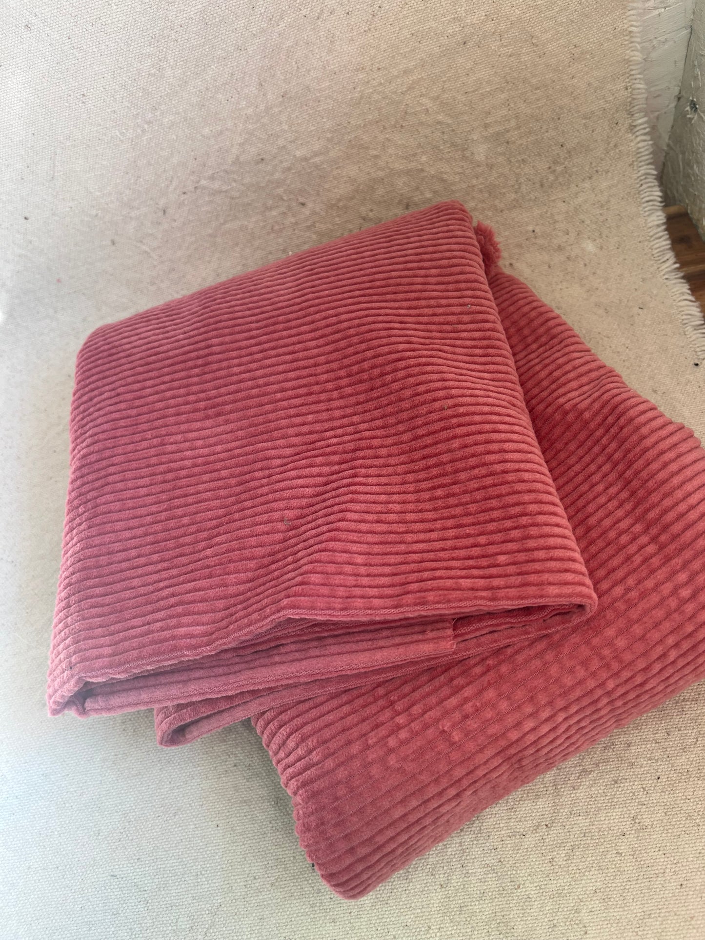 Folded pink corduroy fabric.