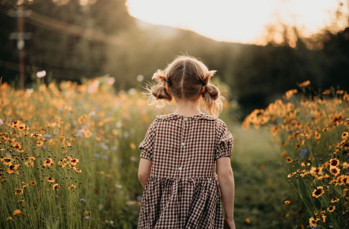 Girl with pigtails in a field of wildflowers.
