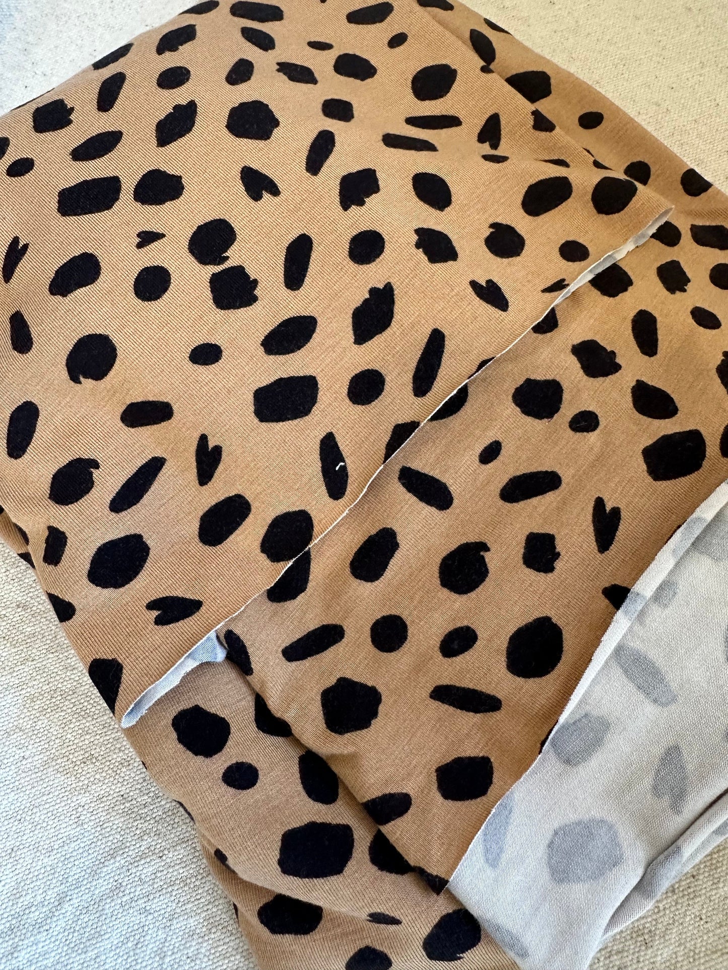 Tan fabric with black spots.