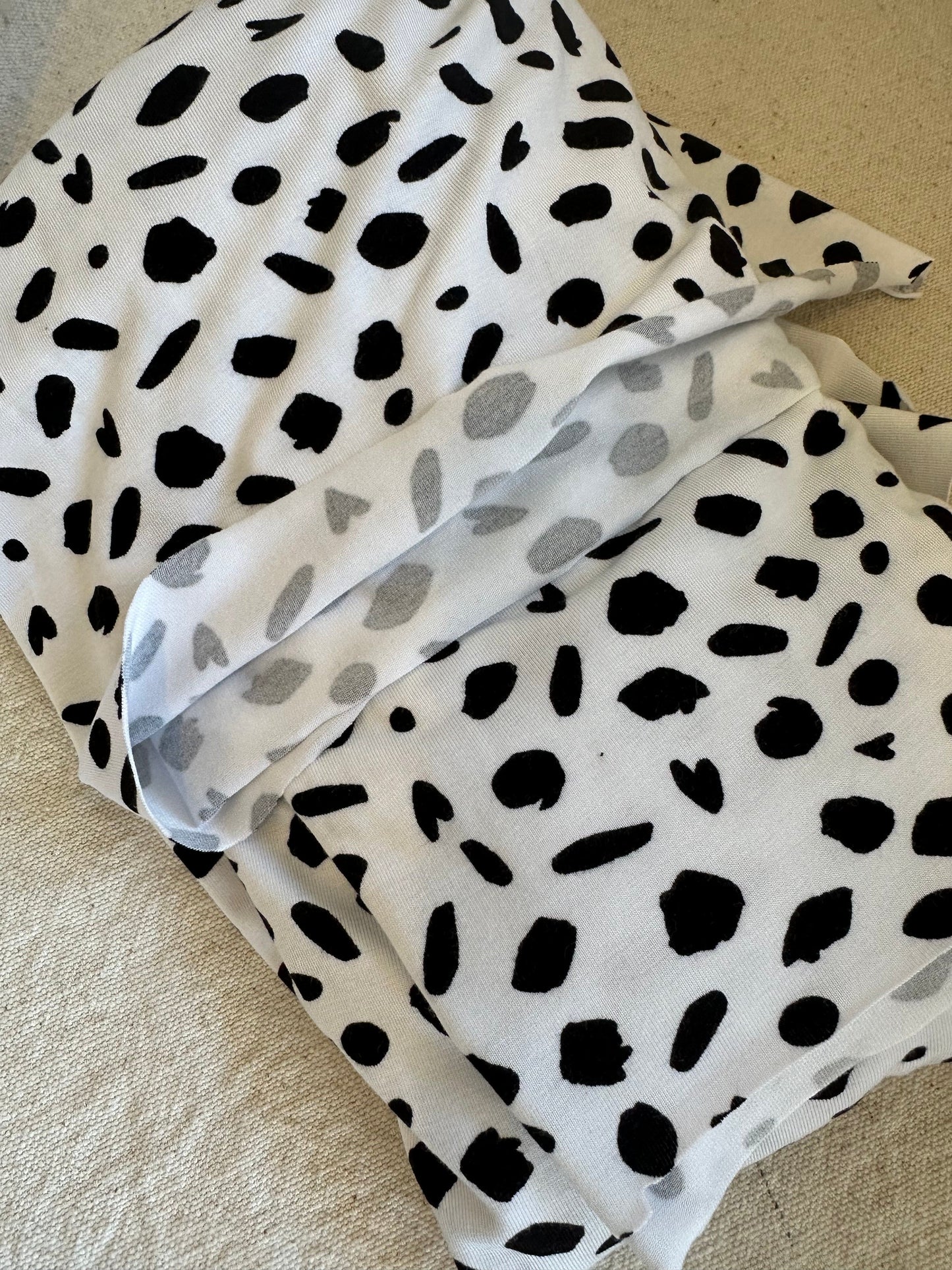 White fabric with black spots.