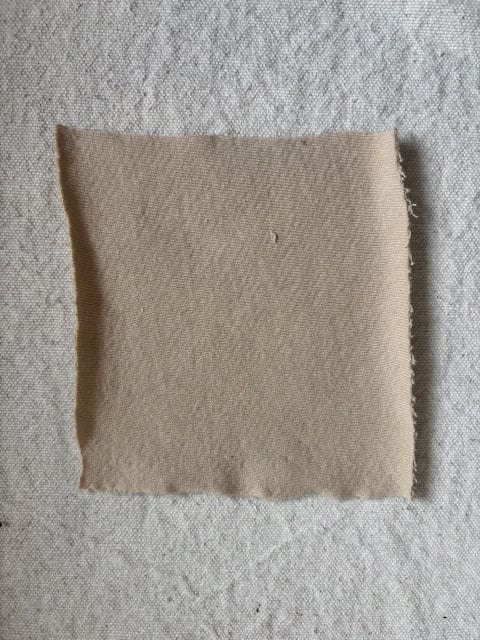 Beige square fabric swatch.