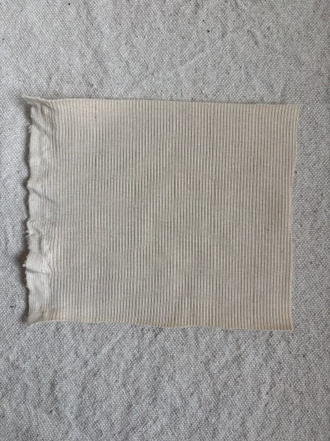 Off-white ribbed fabric swatch.