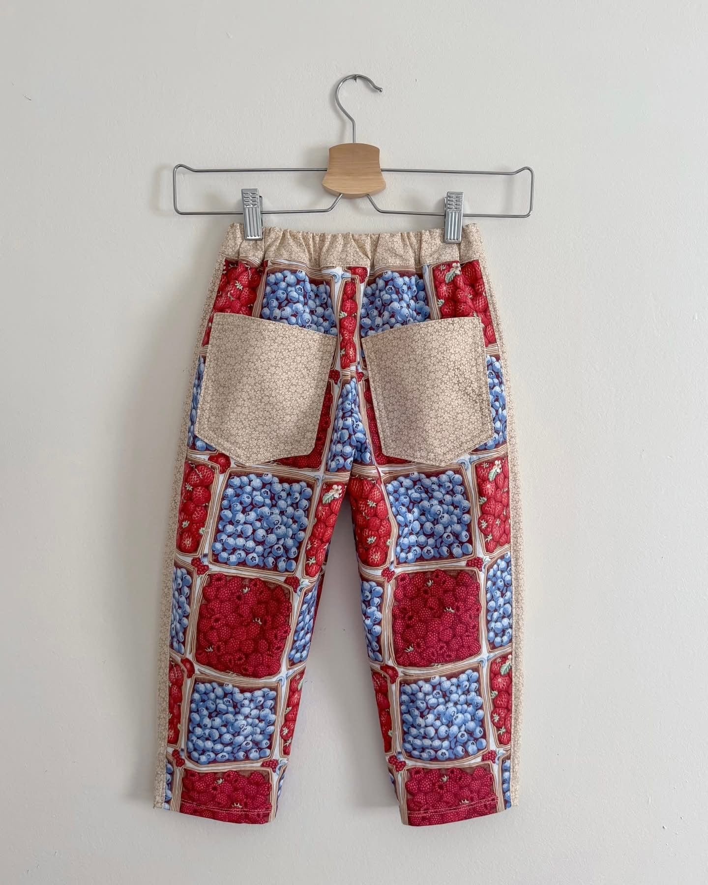 Children's patterned pants hanging on a hanger.