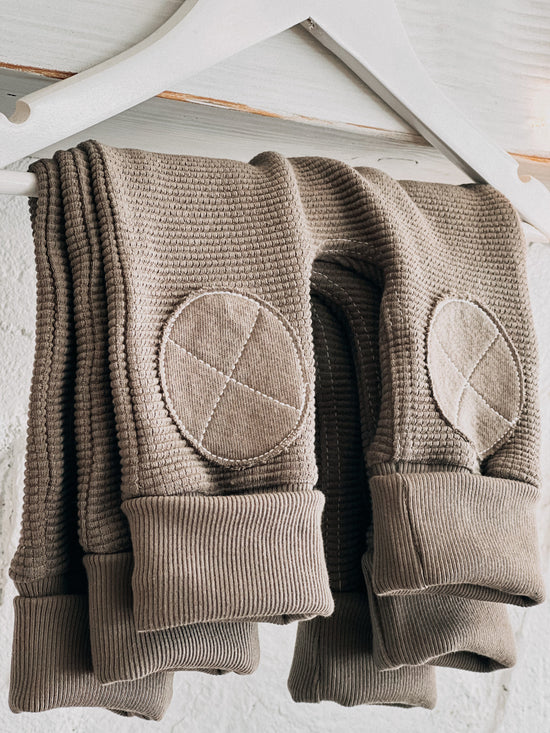 Jo's brown knit baby pants on a hanger